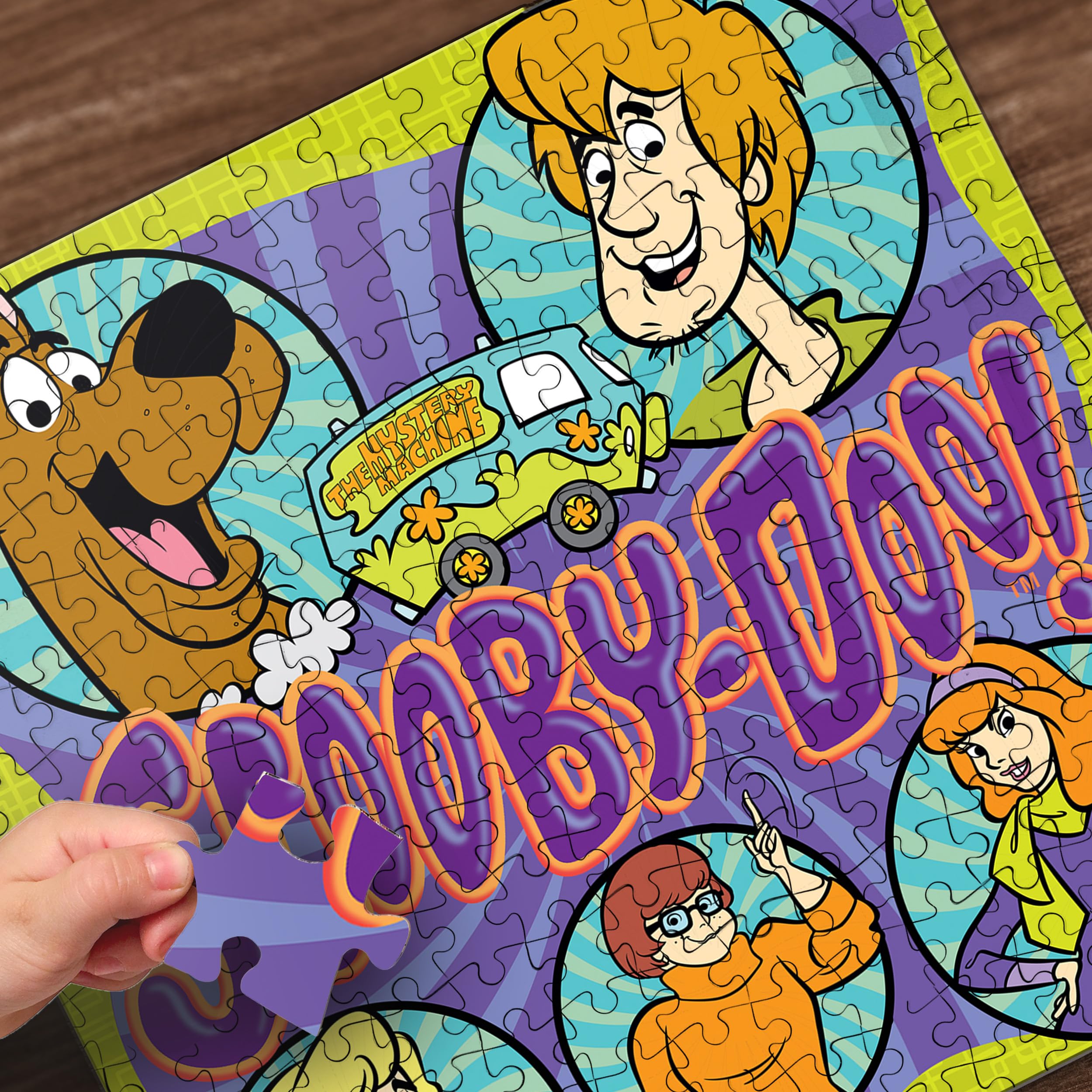 MasterPieces Scooby-Doo puzzle pieces spread on a table inviting collaboration
