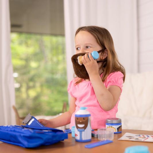 Vibrating trimmer in Melissa & Doug set provides lifelike grooming play—no batteries needed.