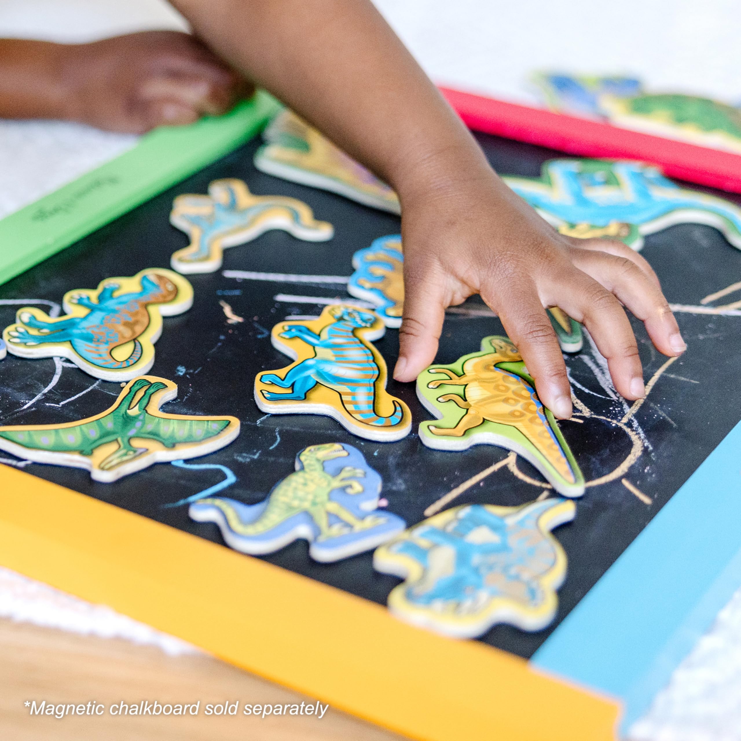 Dinosaur magnets resting in the wooden case by Melissa & Doug