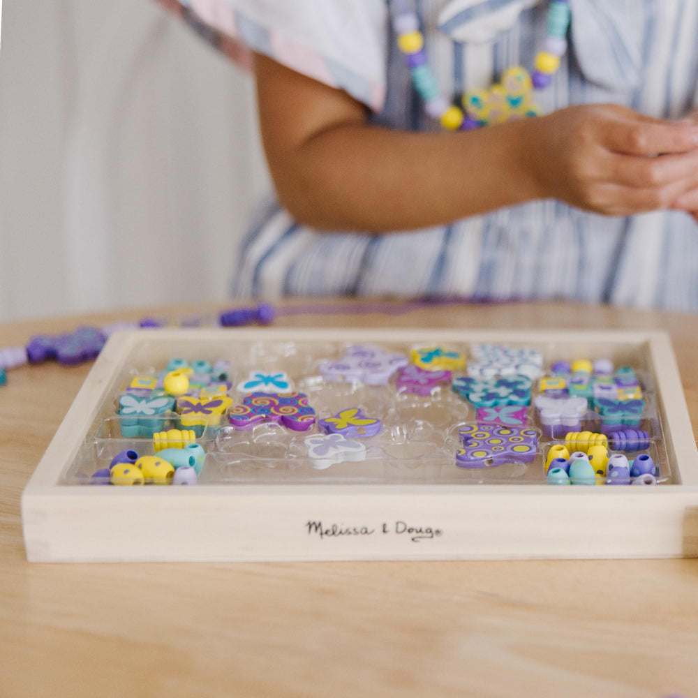 Pattern-building with Melissa & Doug beads across cords