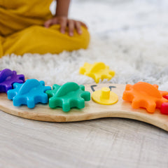 Gears rotate on the Rainbow Caterpillar Gear Toy illustrating motion and cause-and-effect