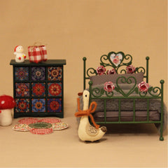 Art-nouveau floral engravings add timeless elegance to the miniature bed.
