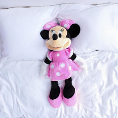 Child hugging Minnie 10782 plush, a cozy playtime friend.