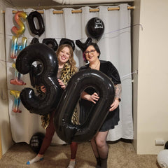 Mluchee number 0 balloon used as a photo booth prop for memories.
