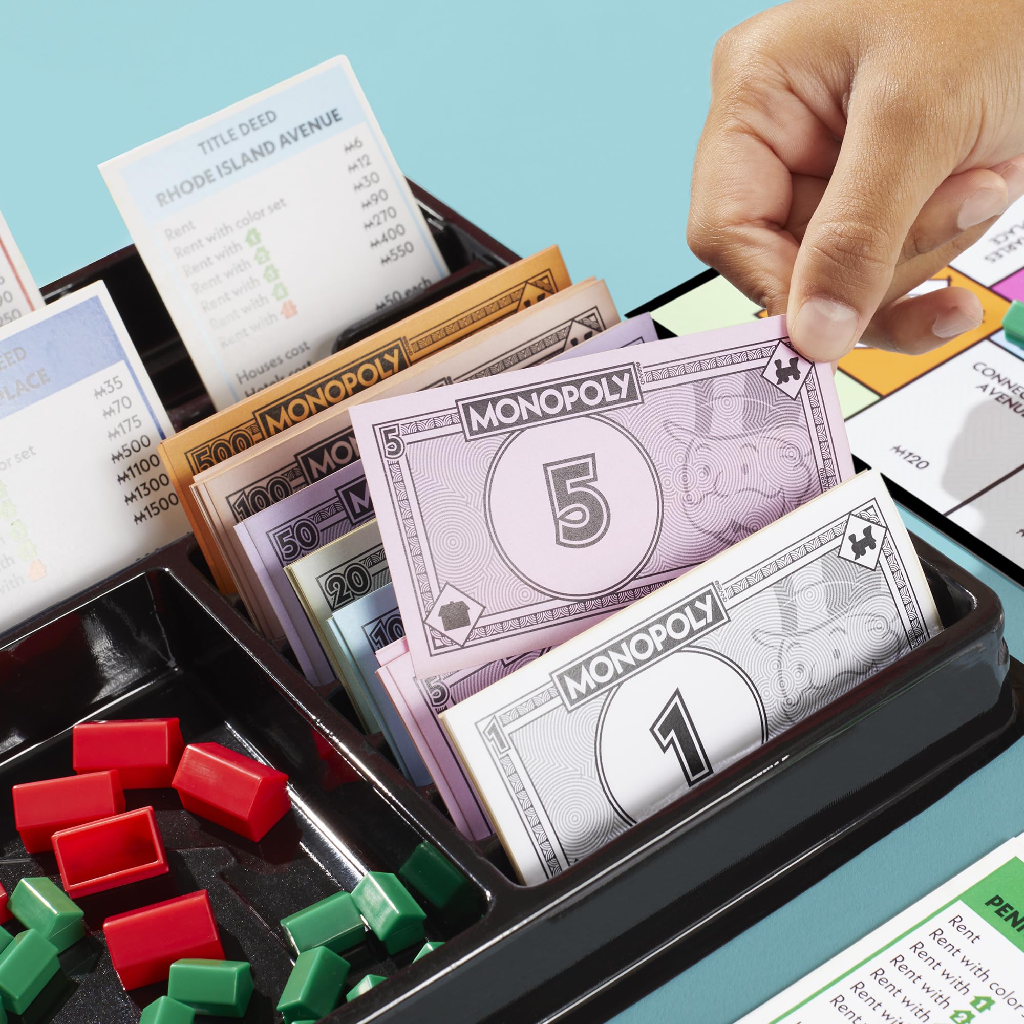 Monopoly money and title deeds organized for fast reference during turns.