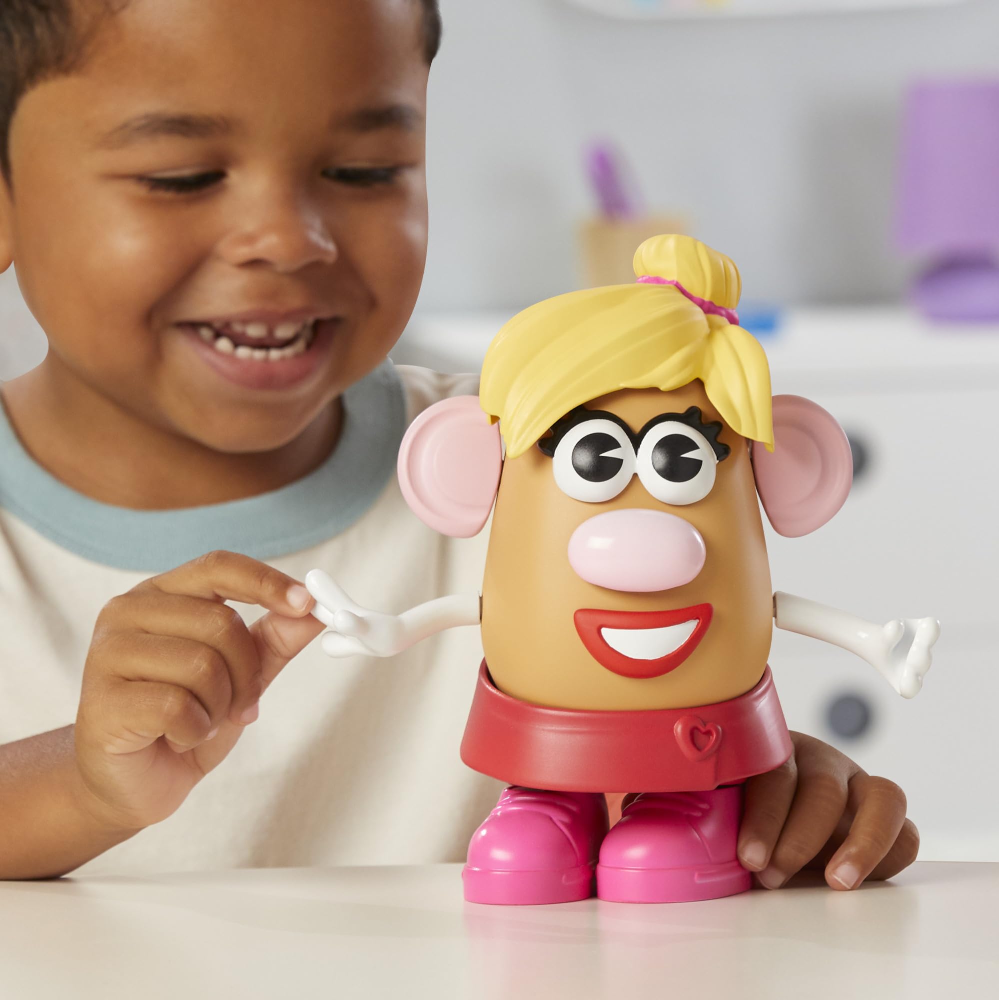 Child mixes eyes, ears, nose, and mouth to create new Mr. Potato Head faces.