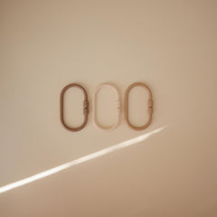 Mushie Chain Link Rings in shifting sand color support on-the-go play and easy access to toys.