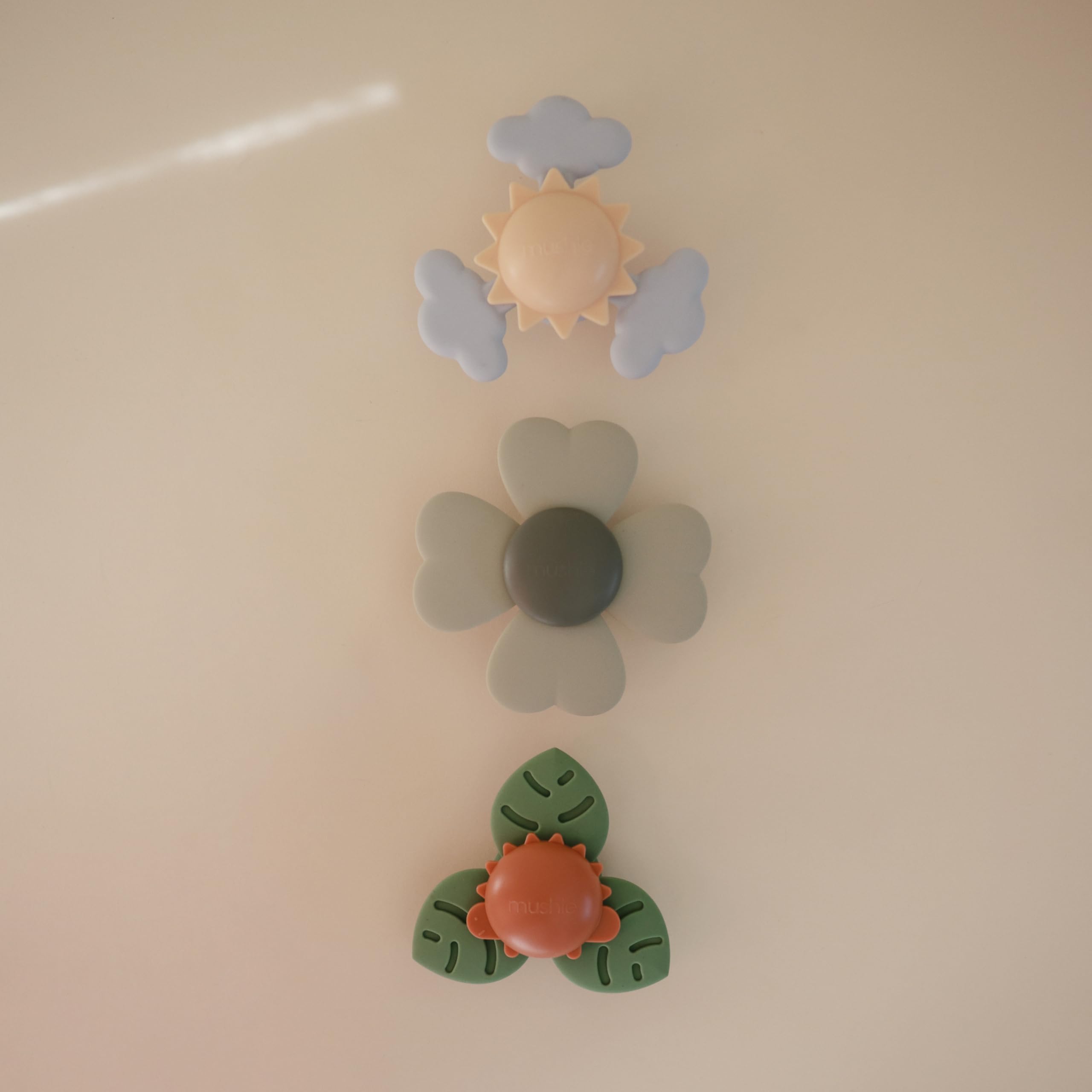 Mushie Lucky Suction Spinner Toy on airplane tray supports calm exploration.