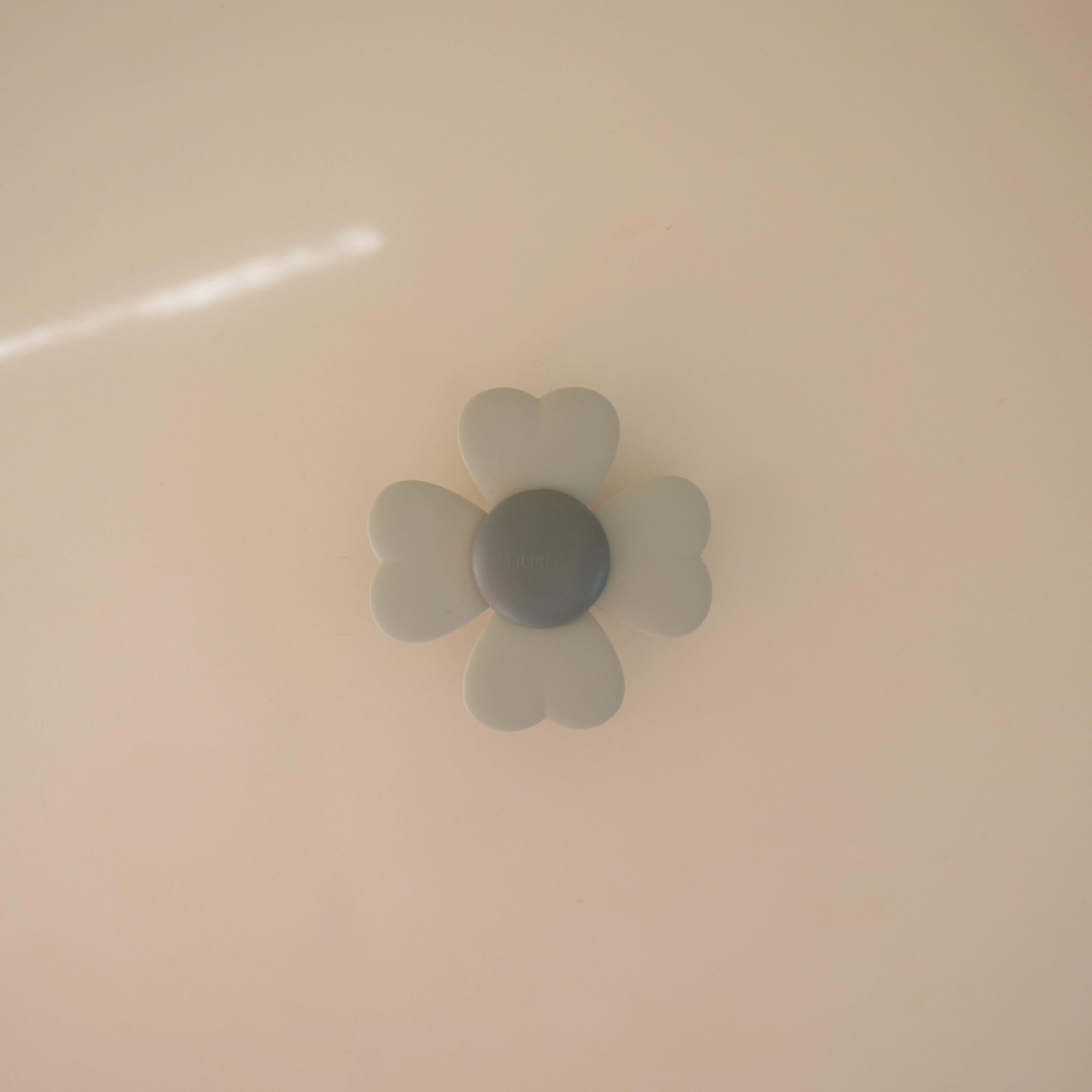 Mushie Lucky Suction Spinner Toy sticks to a cabinet door for on-the-go distraction.