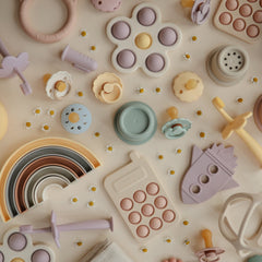 Mushie Phone Press Toy Blush being cleaned with warm soapy water