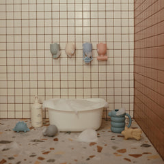 Mushie Pour and Play set showing different openings for water flow patterns