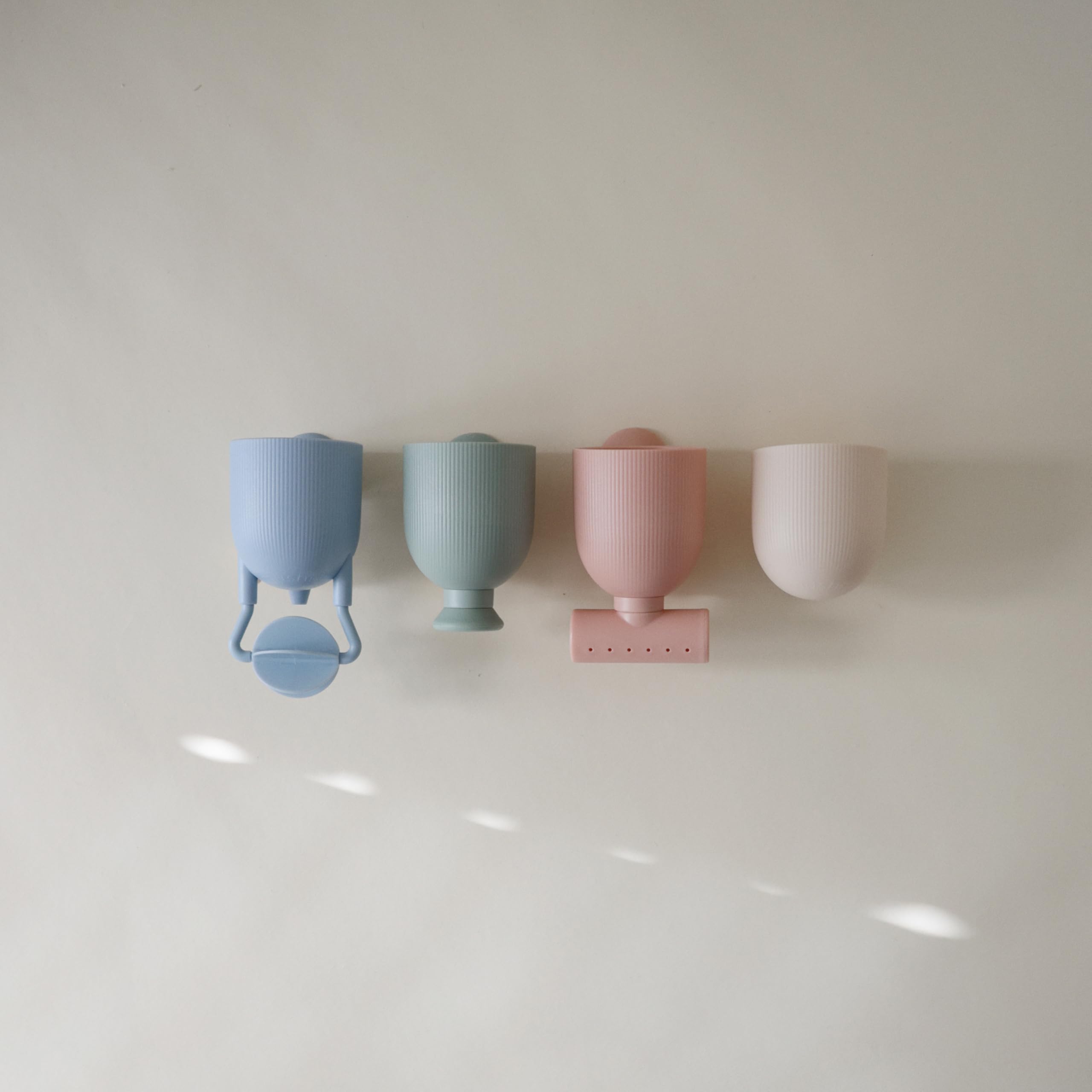 Mushie bath toy with suction cups secured to tub wall for creative waterfall setups