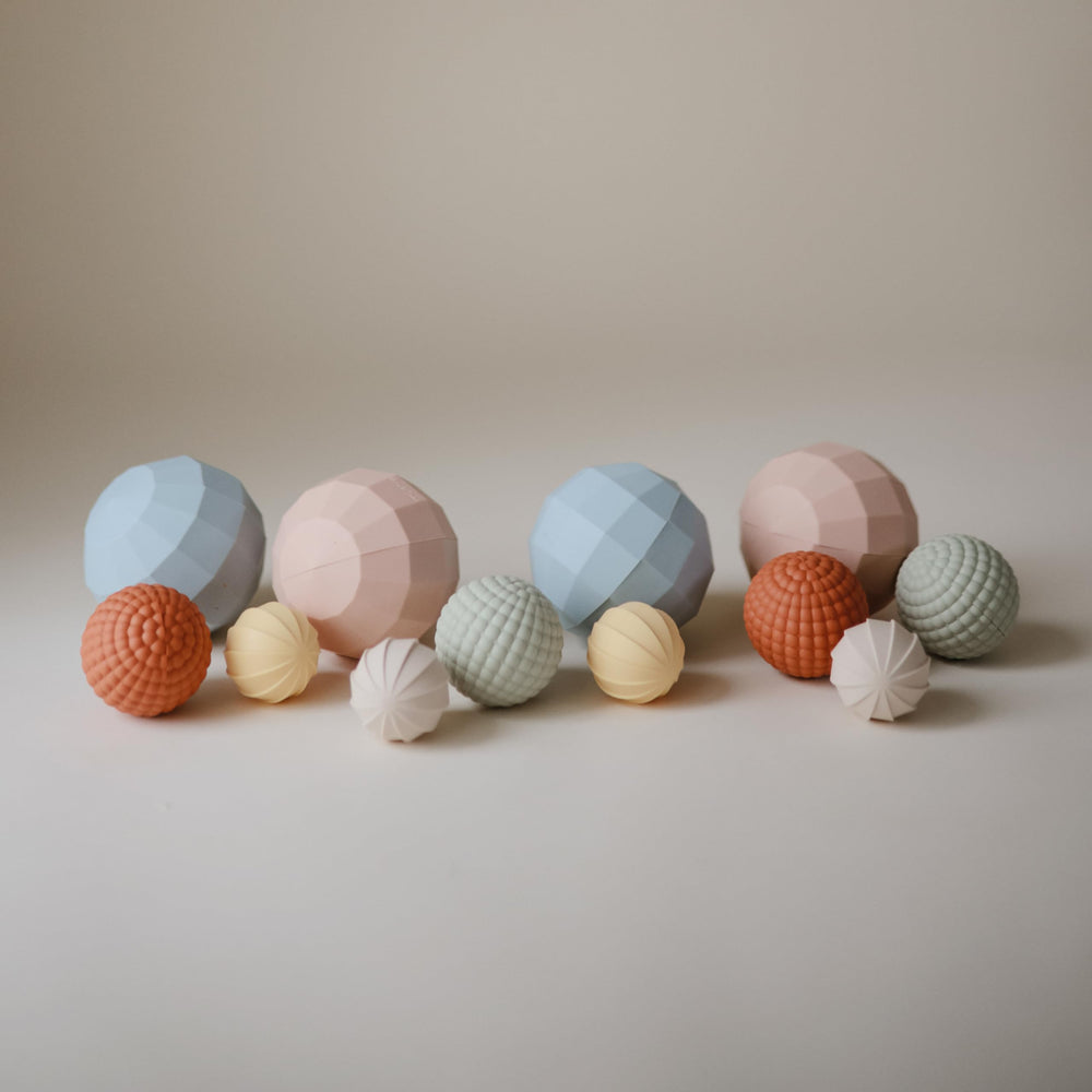 Mushie silicone nesting-spheres blush smallest-rattle enhances auditory play.