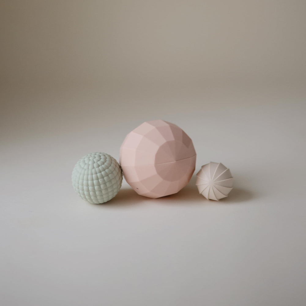 Mushie silicone spheres blush pack-3 promotes gentle stacking and sorting.