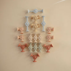 Mushie silicone suction builder daisy pieces demonstrate safe, non-toxic construction for curious hands.