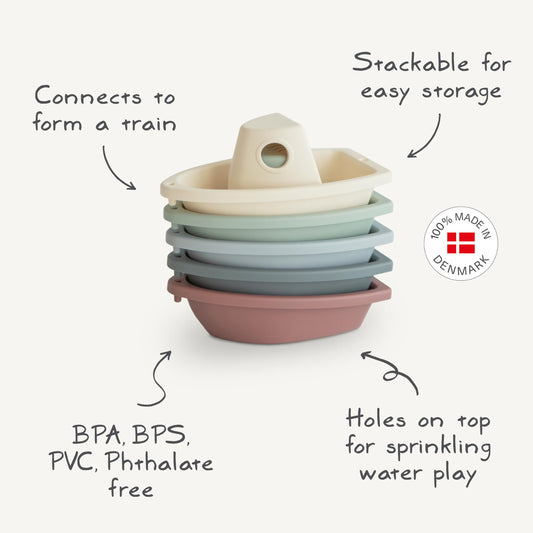 Mushie Stackable Bath Boats Petal floating as a train in the tub.