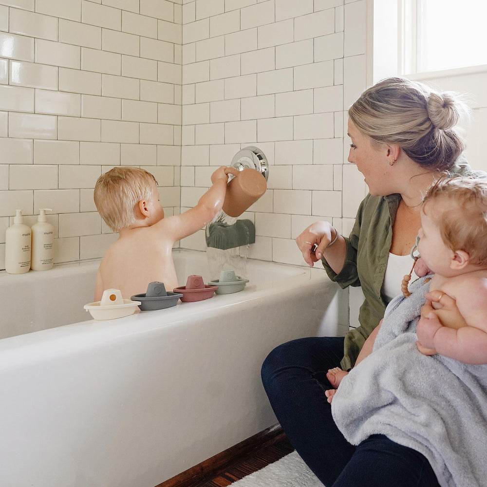 Mushie Petal boats assembled into a floating train for toddlers.
