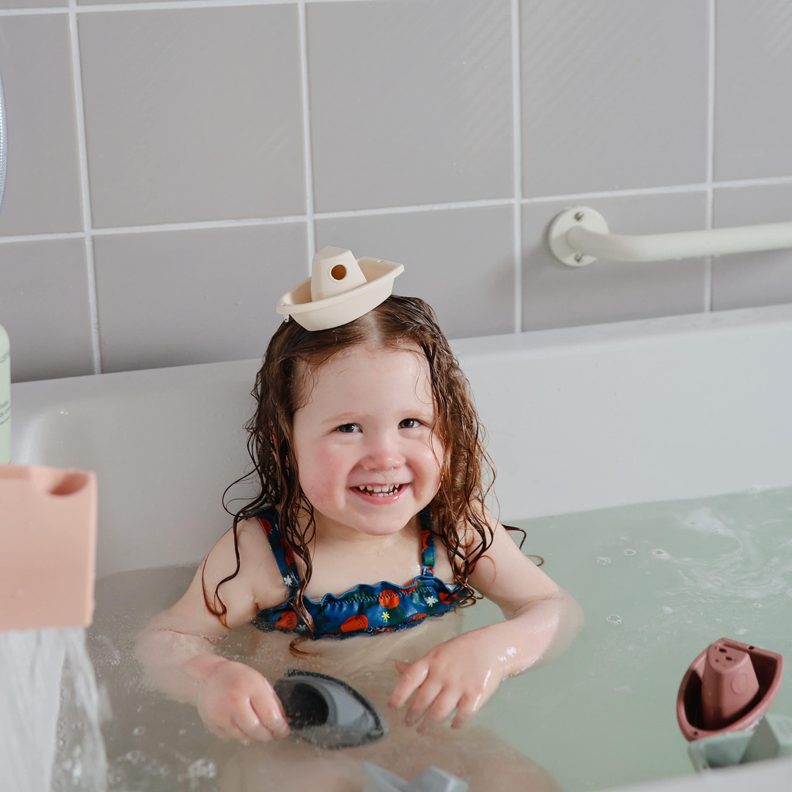 Mushie Stackable Bath Boats Petal on water surface during play.