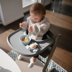 Mushie Sunshine attaches securely to a highchair for independent play