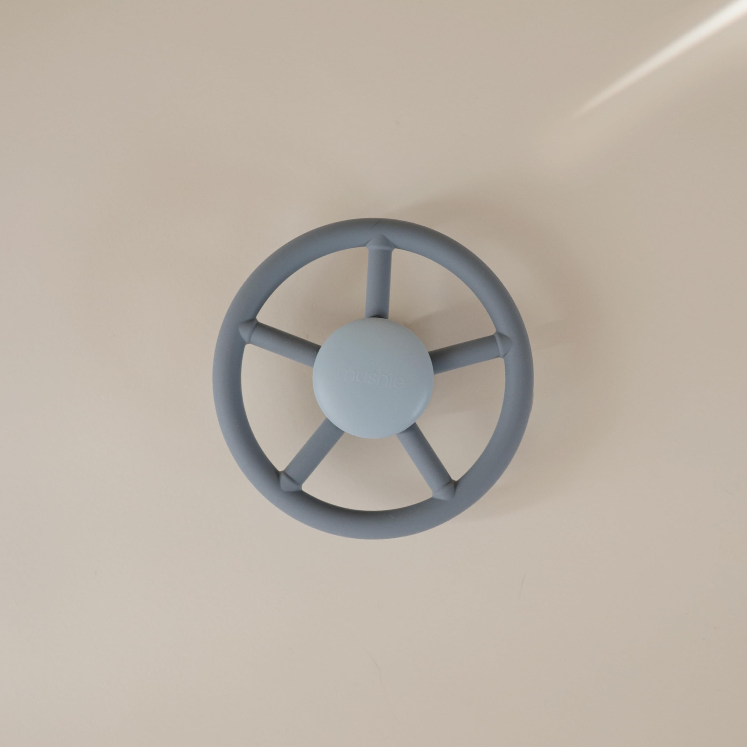 Mushie Wheel leaves spin around a dinosaur center for visual focus.