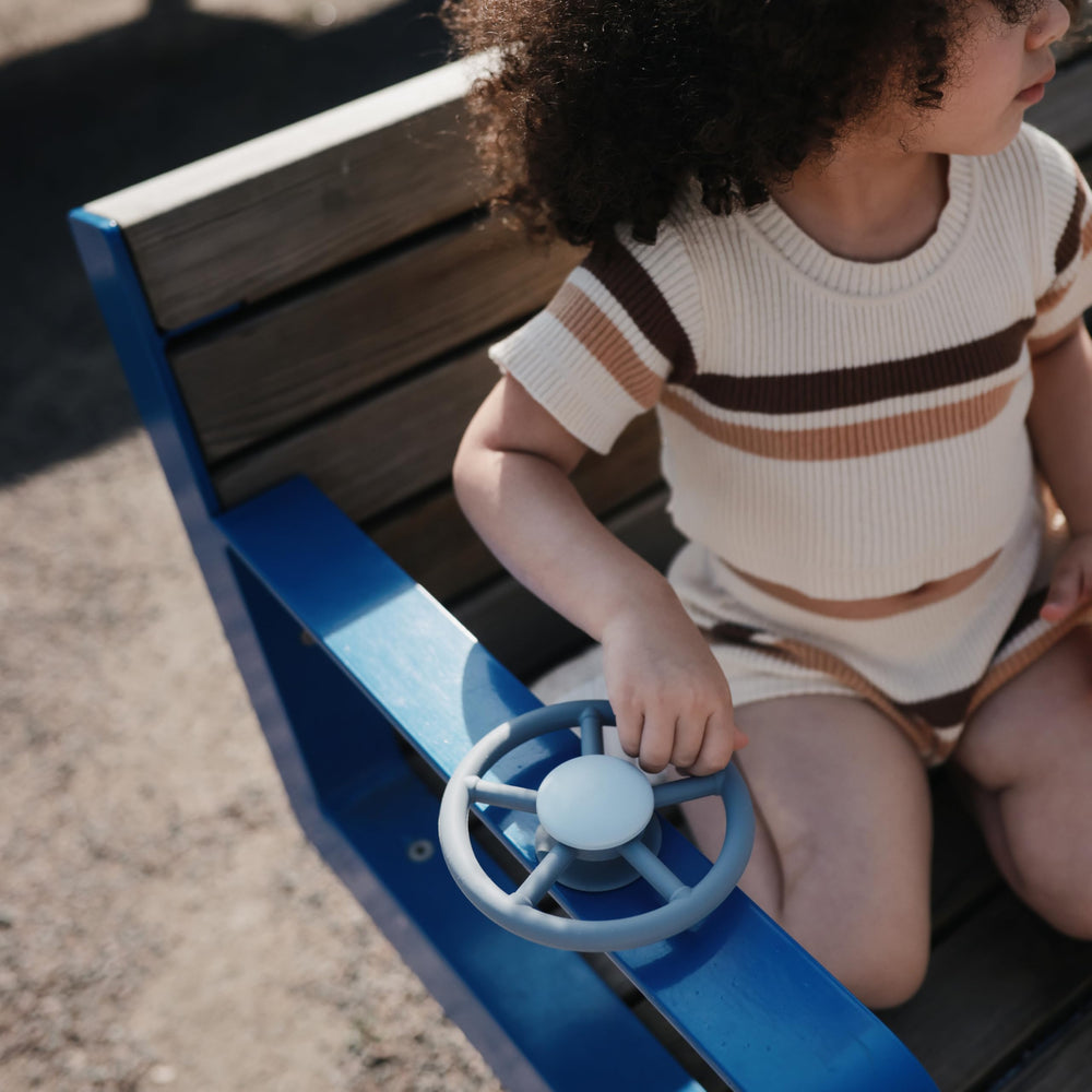 Mushie Wheel suction spinner toy on airplane tray for travel calm.