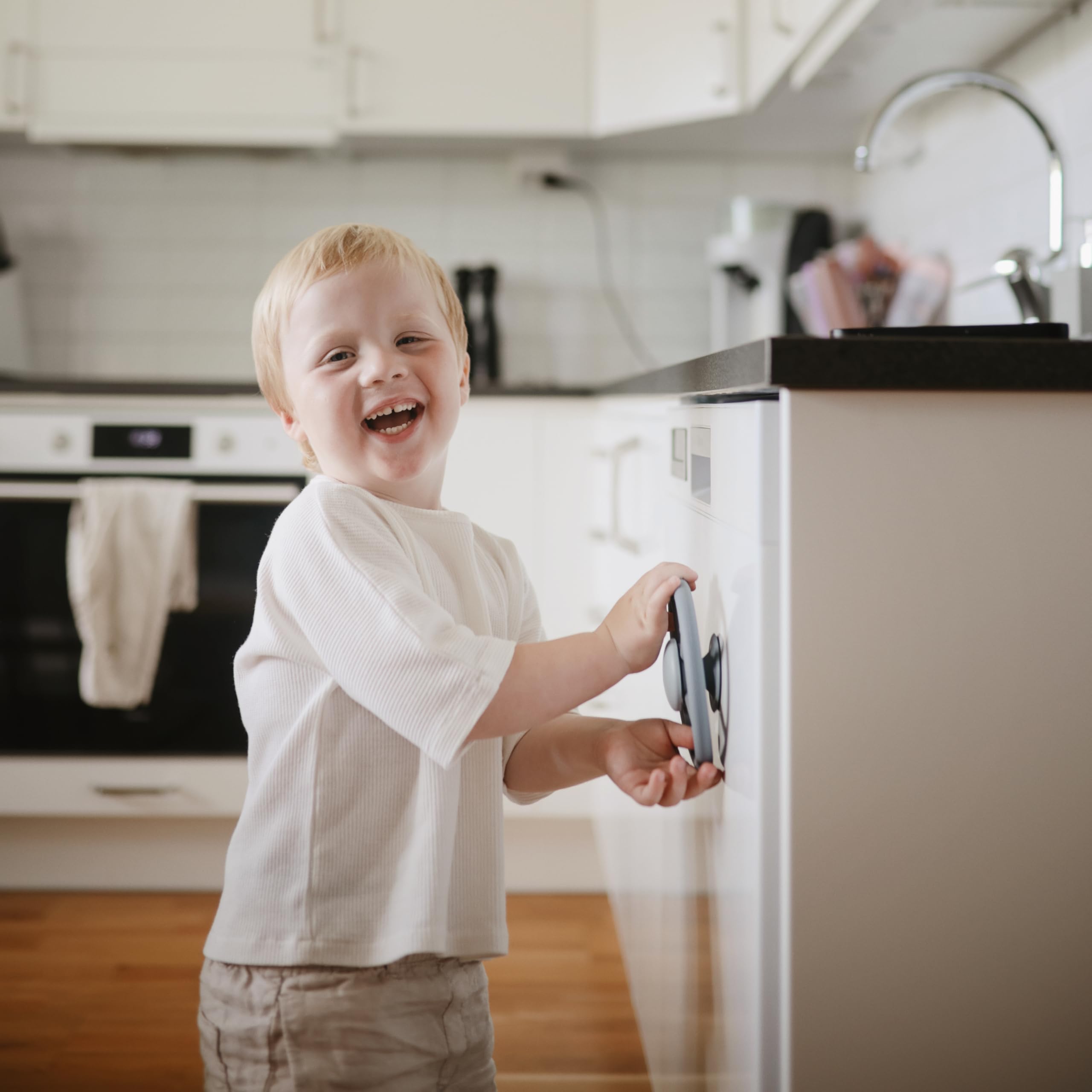 Mushie Wheel suction spinner toy on a cabinet door for engaged play.