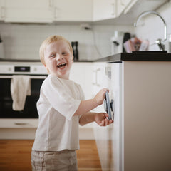 Mushie Wheel suction spinner toy on a cabinet door for engaged play.