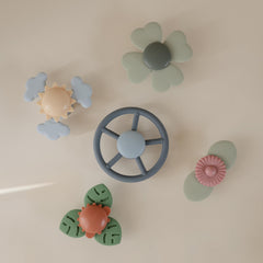 Mushie Wheel suction spinner toy attached to a highchair for independent play.