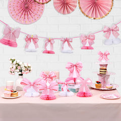 NatNarr pink bow honeycomb centerpiece creates a playful dessert table focal point.