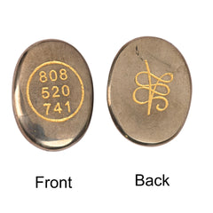 Front view of Natural Pyrite Zibu Coin highlighting engraved symbols and shimmer