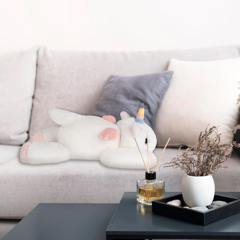 Niuniu Daddy 20in unicorn weighted plush in bed with a child for companionship.