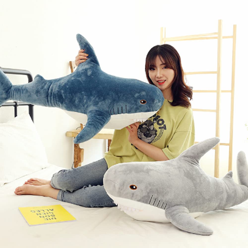 OPHRBU blue shark plush as lumbar pillow at desk.
