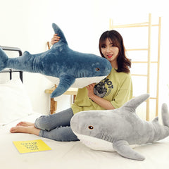 OPHRBU blue shark plush as lumbar pillow at desk.