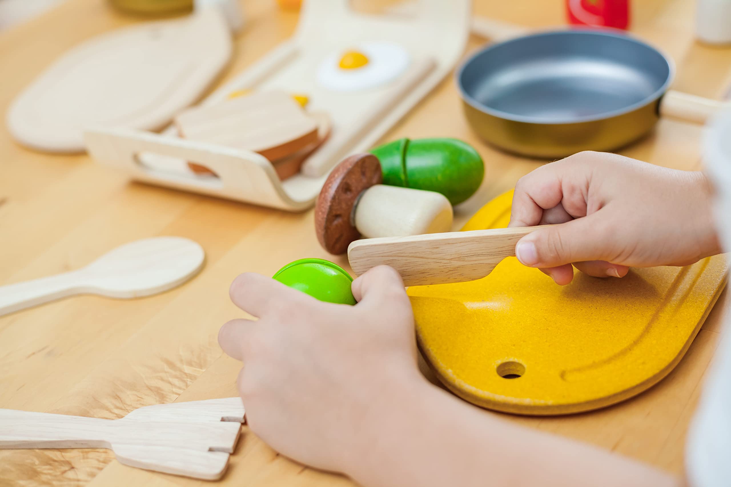 PlanToys five vegetable pieces cut and rejoined for fine motor play.