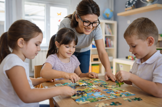 Teacher assisting children with a puzzle in a classroom setting