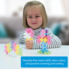 PLUS PLUS Big kid playing with pastel blocks in a cozy setting