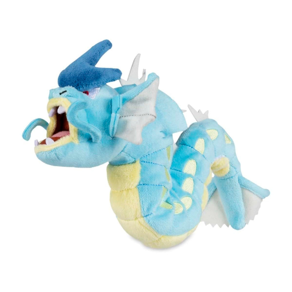 Pokémon Center Gyarados Sitting Cuties Plush upright on a desk for playful display.