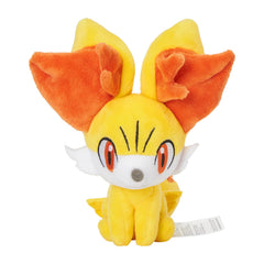 Pokémon Center Fennekin plush sits upright on desk for easy display.