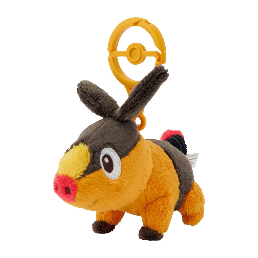 Pokémon Tepig plush on a backpack via carabiner for easy portability.