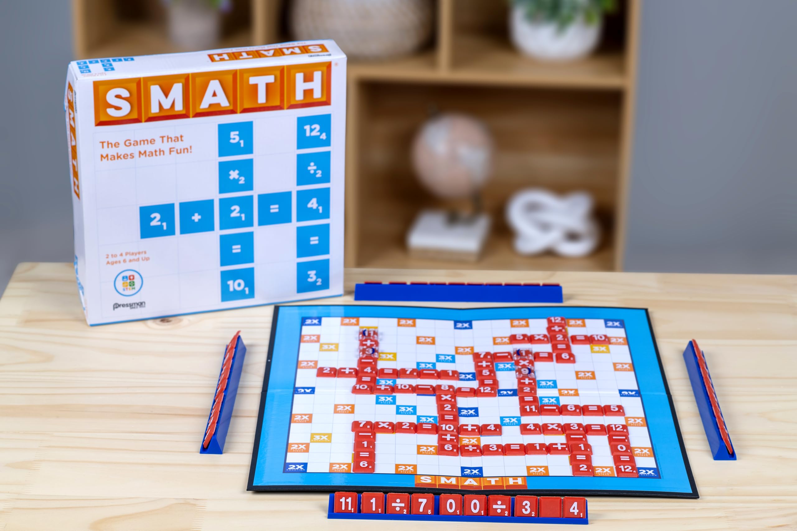 Two players strategize on a colorful Smath board during family game night.