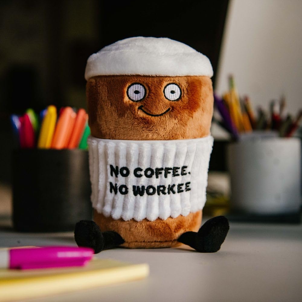 Punchkins Coffee Plushie desk display beside books enhances cozy workspace decor.