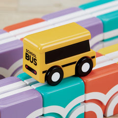 QBI child playing with bus proves portable, travel-friendly learning on the go.