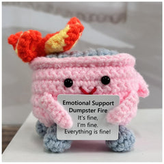 RovyFota emotional support dumpster fire pink plush on a desk, offering cozy encouragement.
