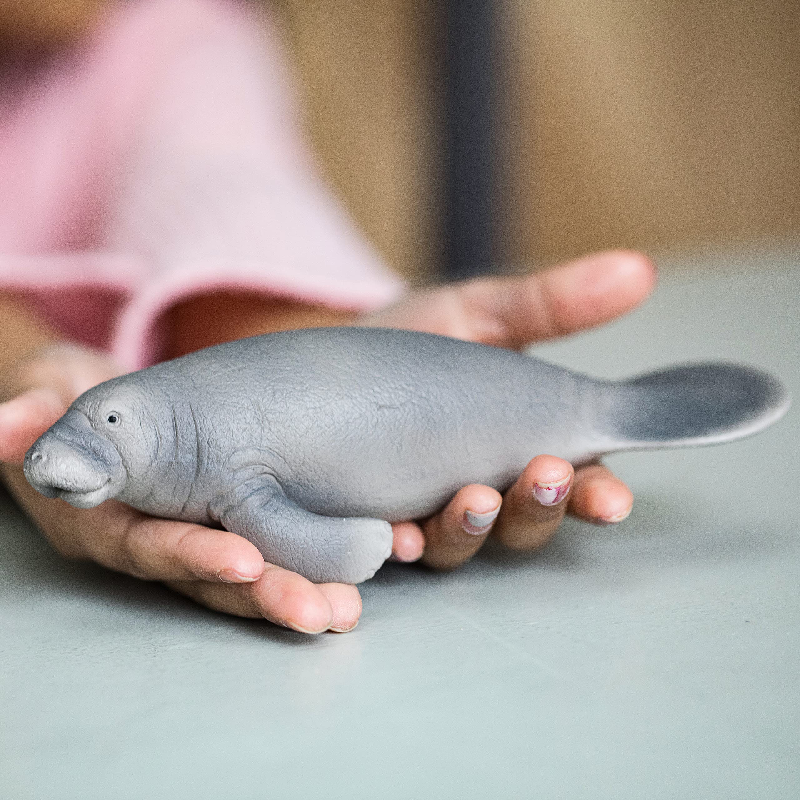 Schleich Wild Life manatee figurine in hand supports portable, hands-on learning about marine life.