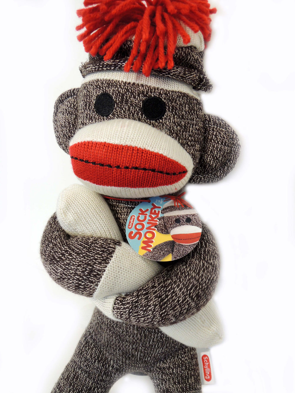 Schylling sock monkey red pompom hat detail highlighting retro charm and playful style.