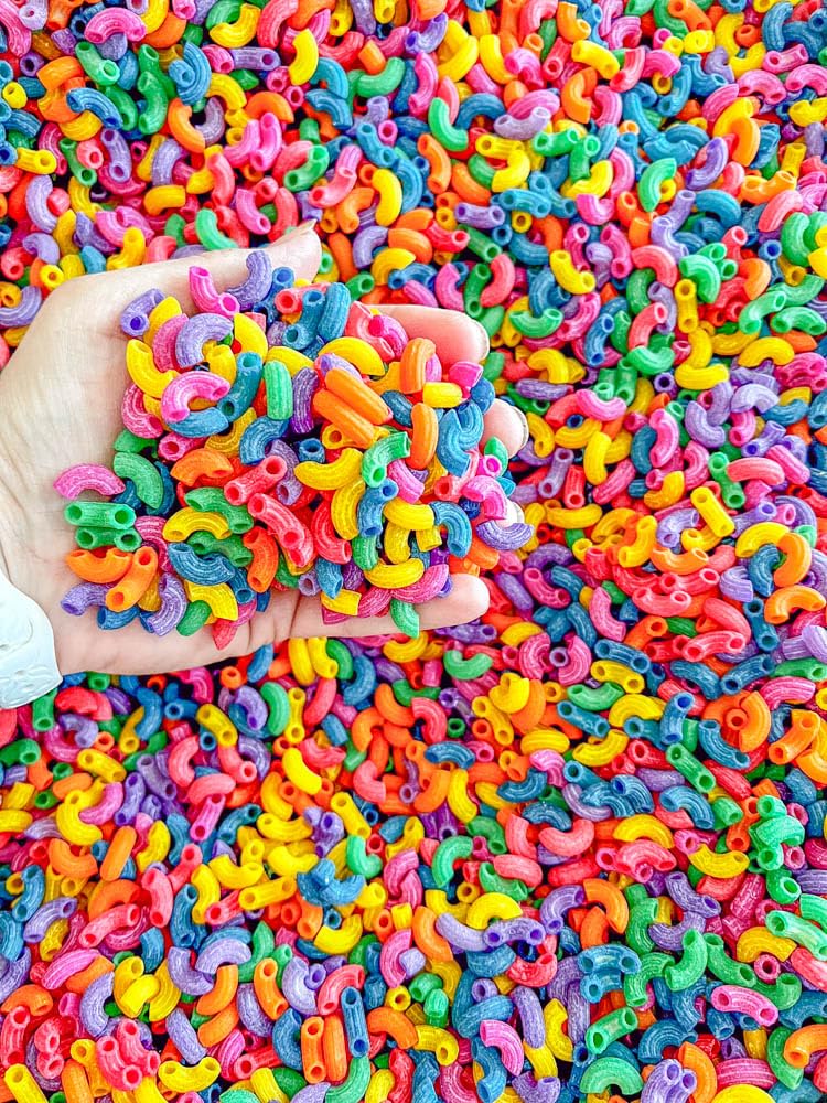 Close-up of Sensory-N-Stuff rainbow elbow pasta showing vivid colors for play.