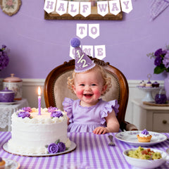 Shanmorine cake smash moment with purple decorations and banner.