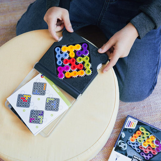 SmartGames IQ Gears gear twist action showing solving process on the puzzle board.