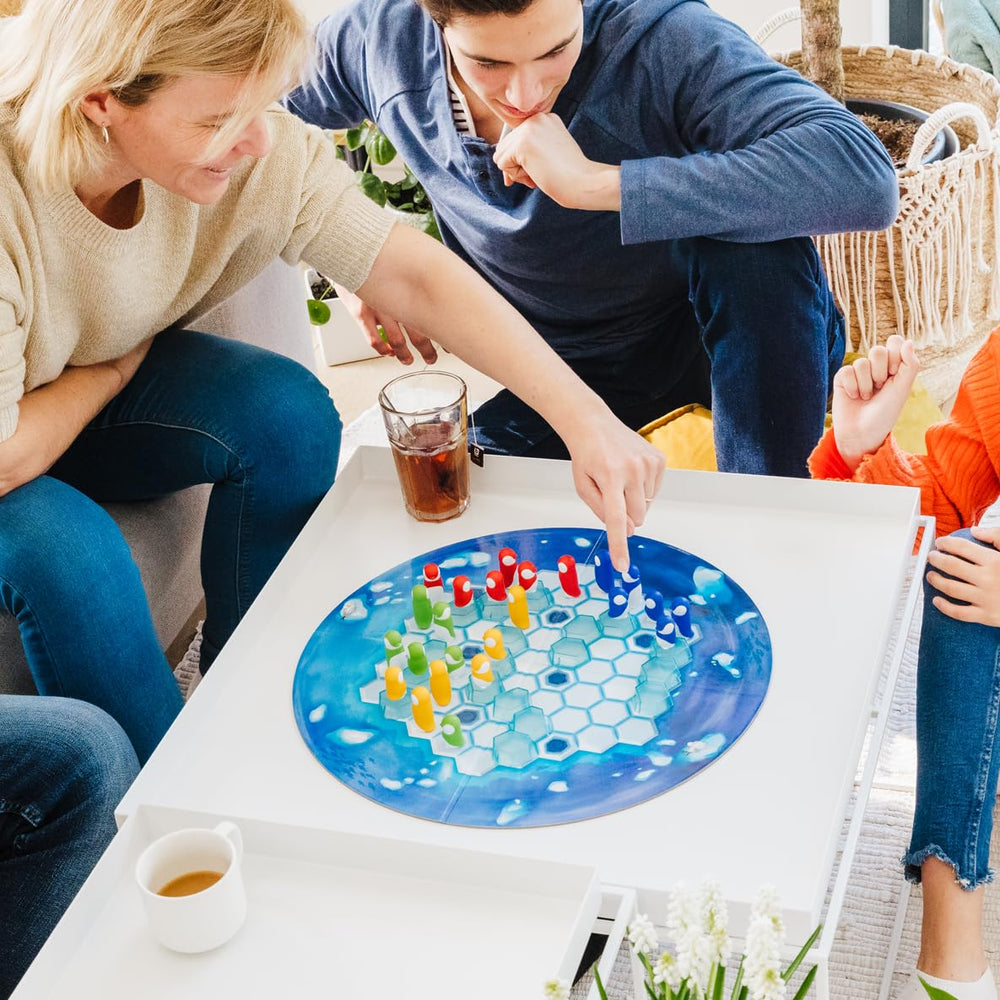 SmartGames Penguins Leader figure on ice tiles enables protective huddle play.