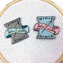 Close-up of Snarky Crafter custom drawn enamel needle minder design